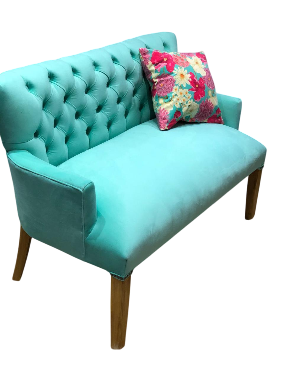 Sofá biplaza de terciopelo rosa fucsia con patas plateadas, vista en ángulo.