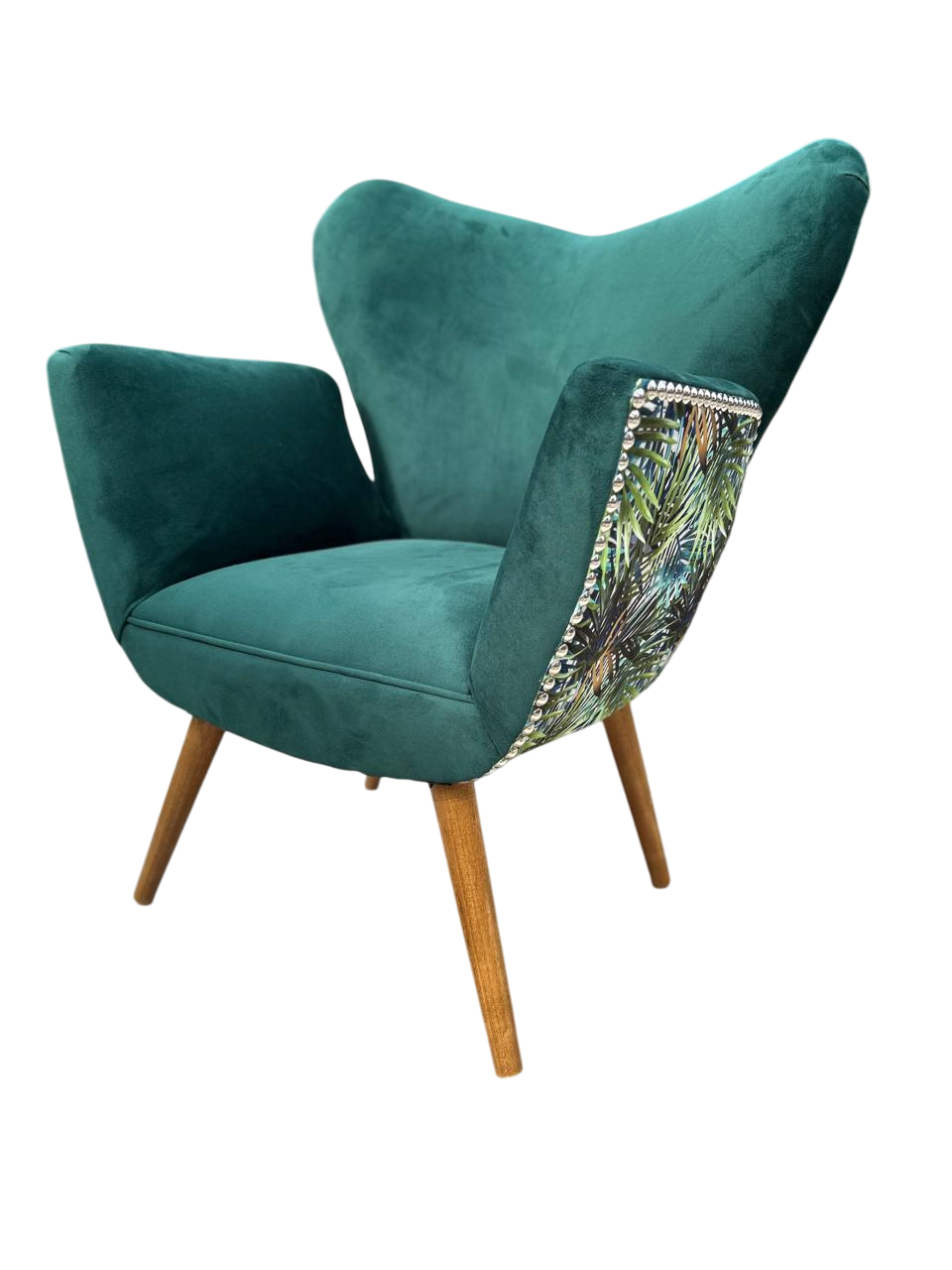 Sillón rosa con respaldo floral, ribete tachonado y patas de madera.