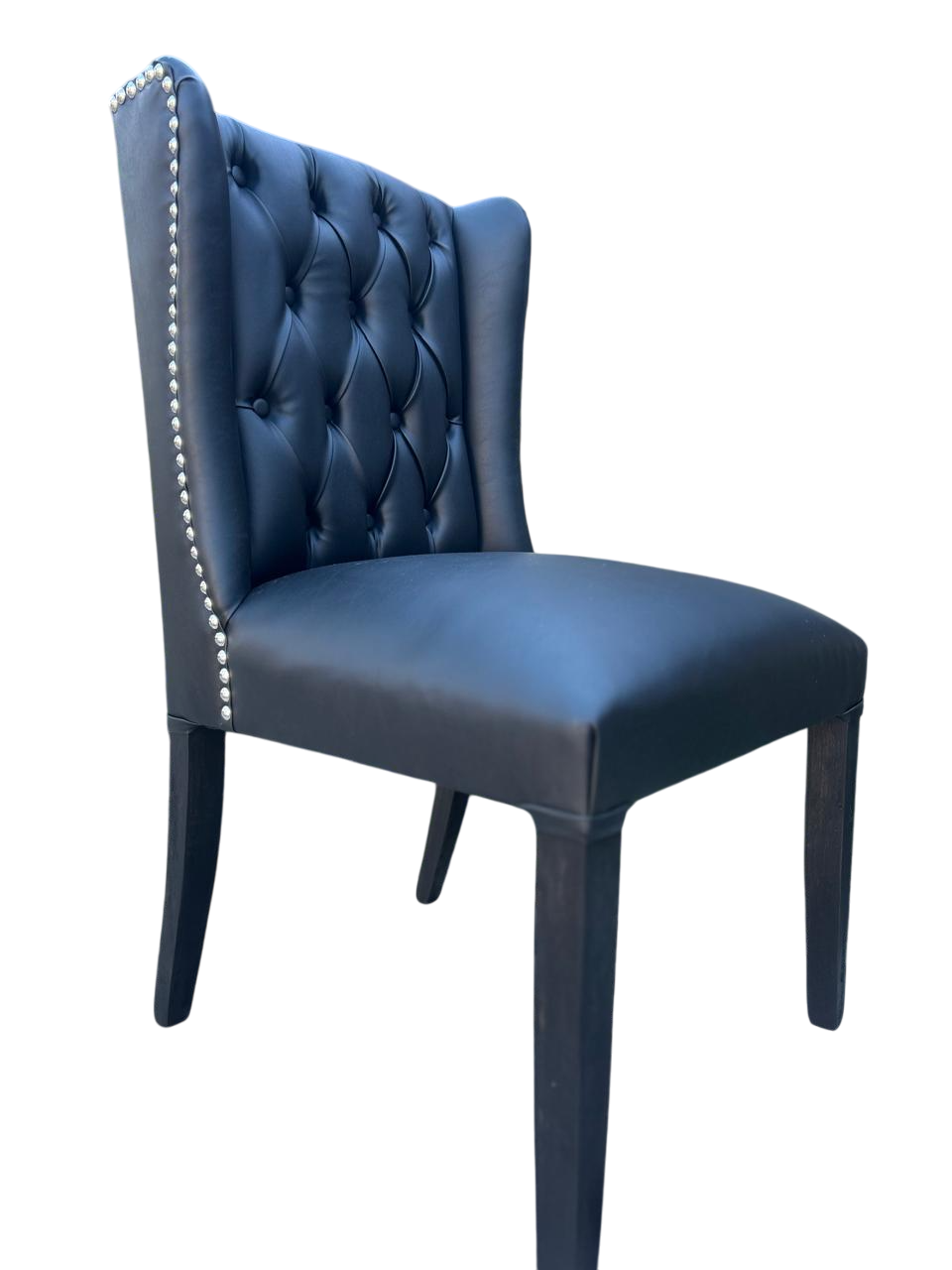 Silla de comedor de terciopelo azul claro con capitoné y patas negras.