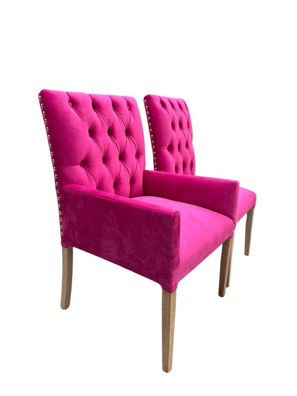 Dos sillones capitoné con tapizado marrón claro y patas de madera.