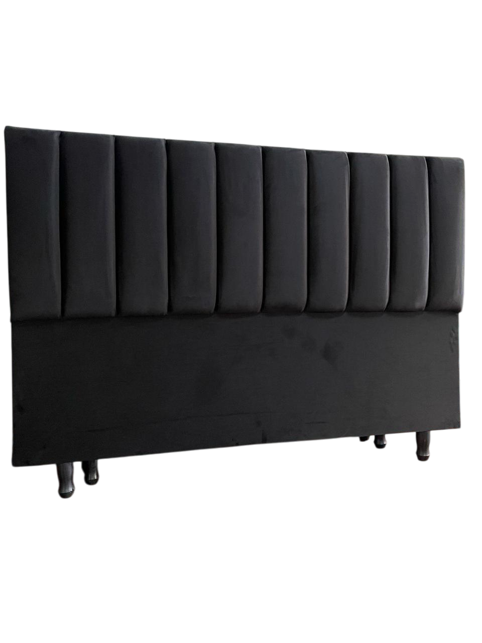 Cabecero tapizado en negro con capitoné vertical.