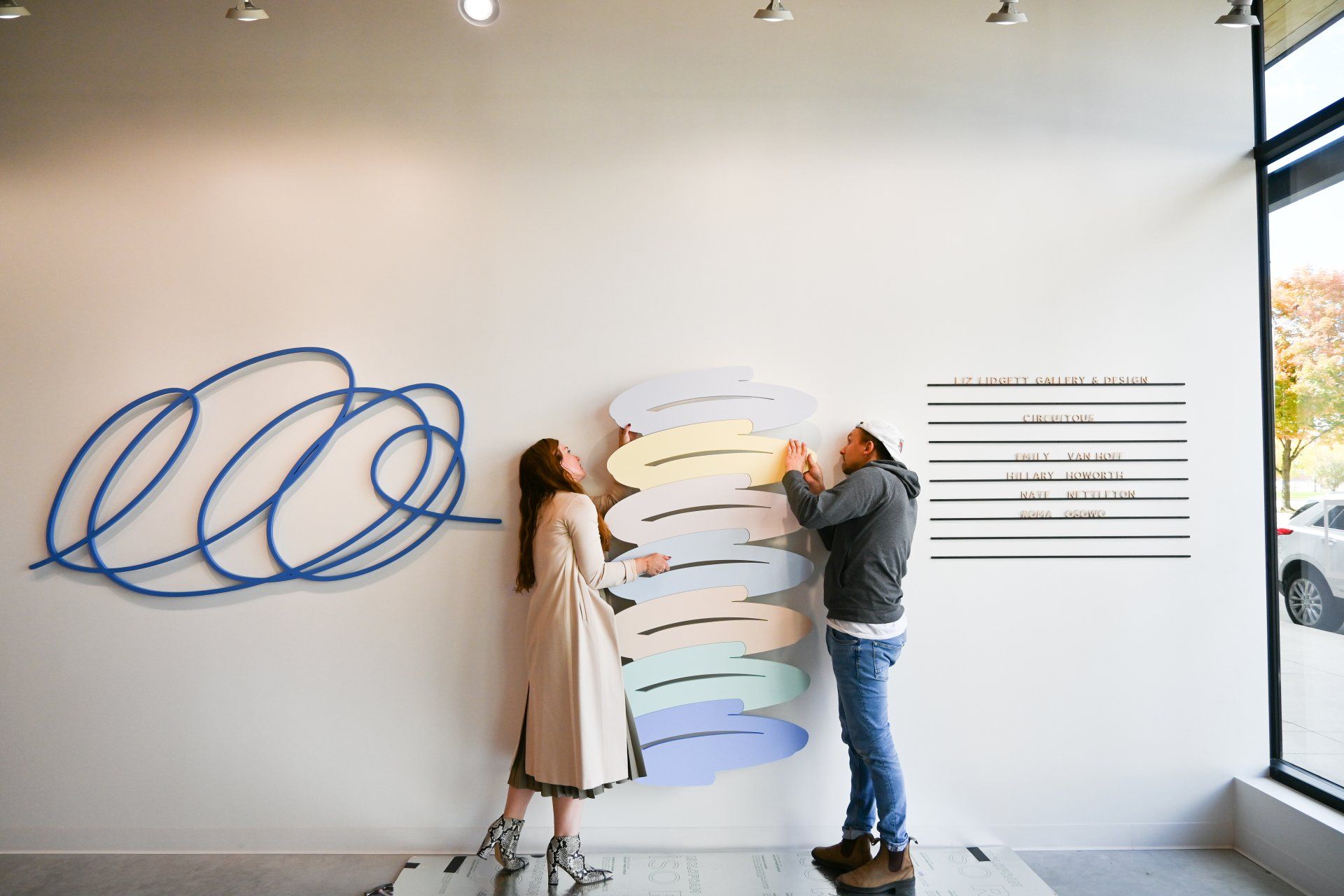 Liz and Nate hanging Nate's artwork on the gallery walls