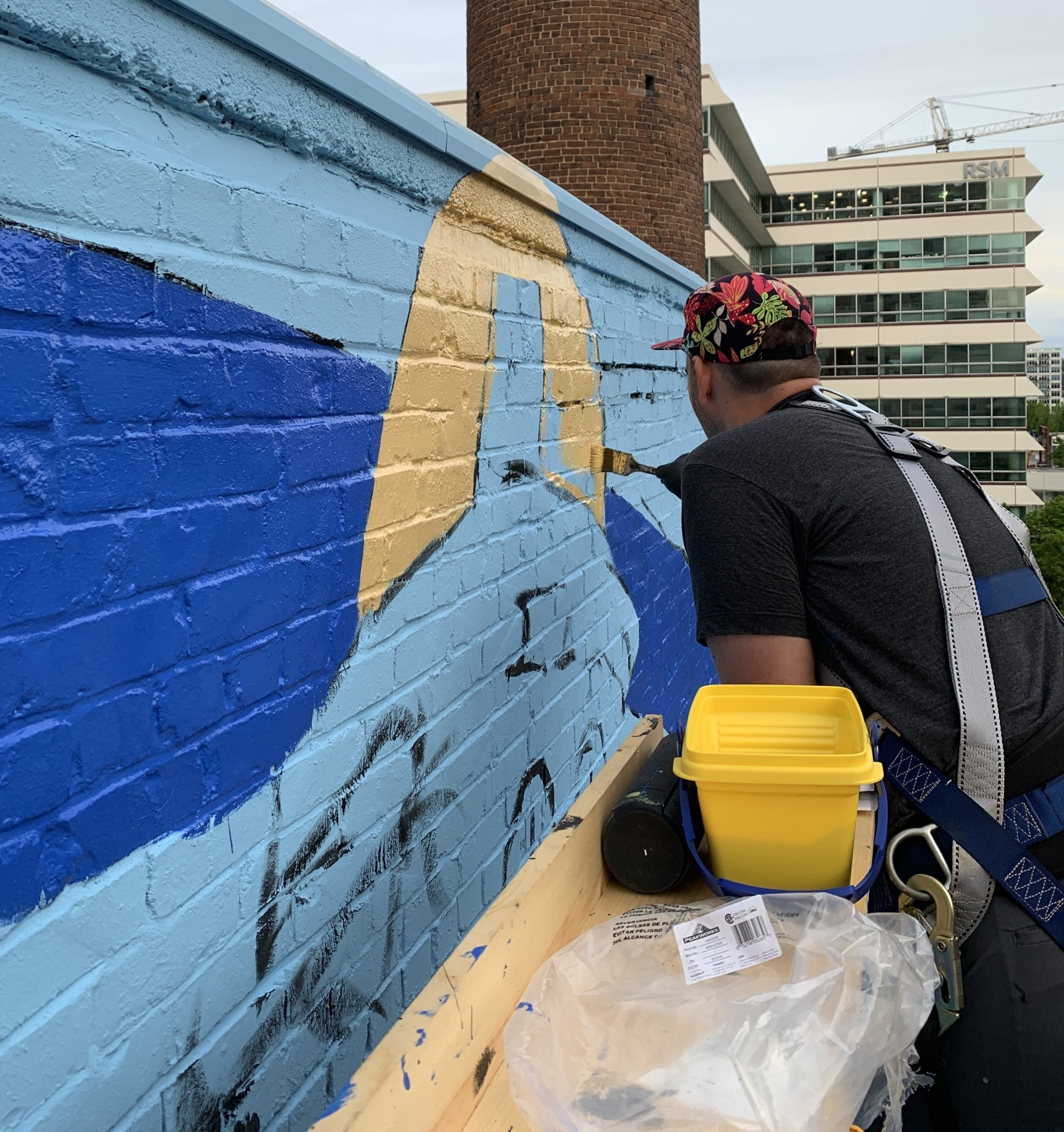 Artist Ben Schuh painting the exterior wall