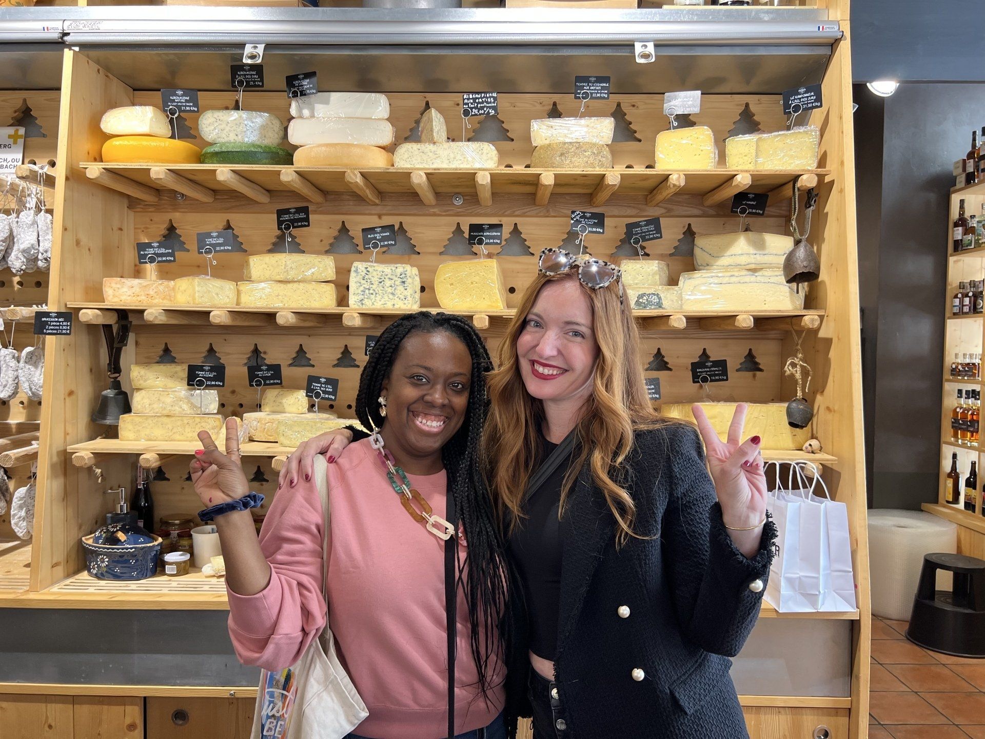 Jessi and Liz in front of a wall of cheese