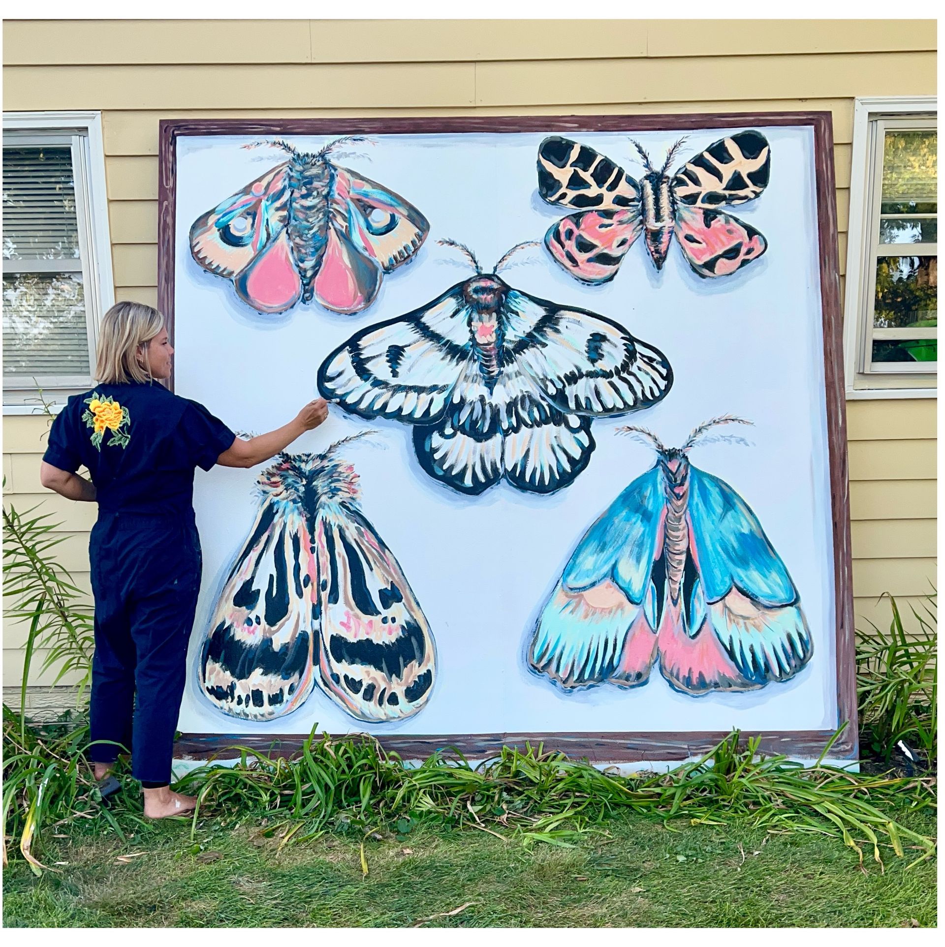 Christine Hilbert painting a Moth inspired mural