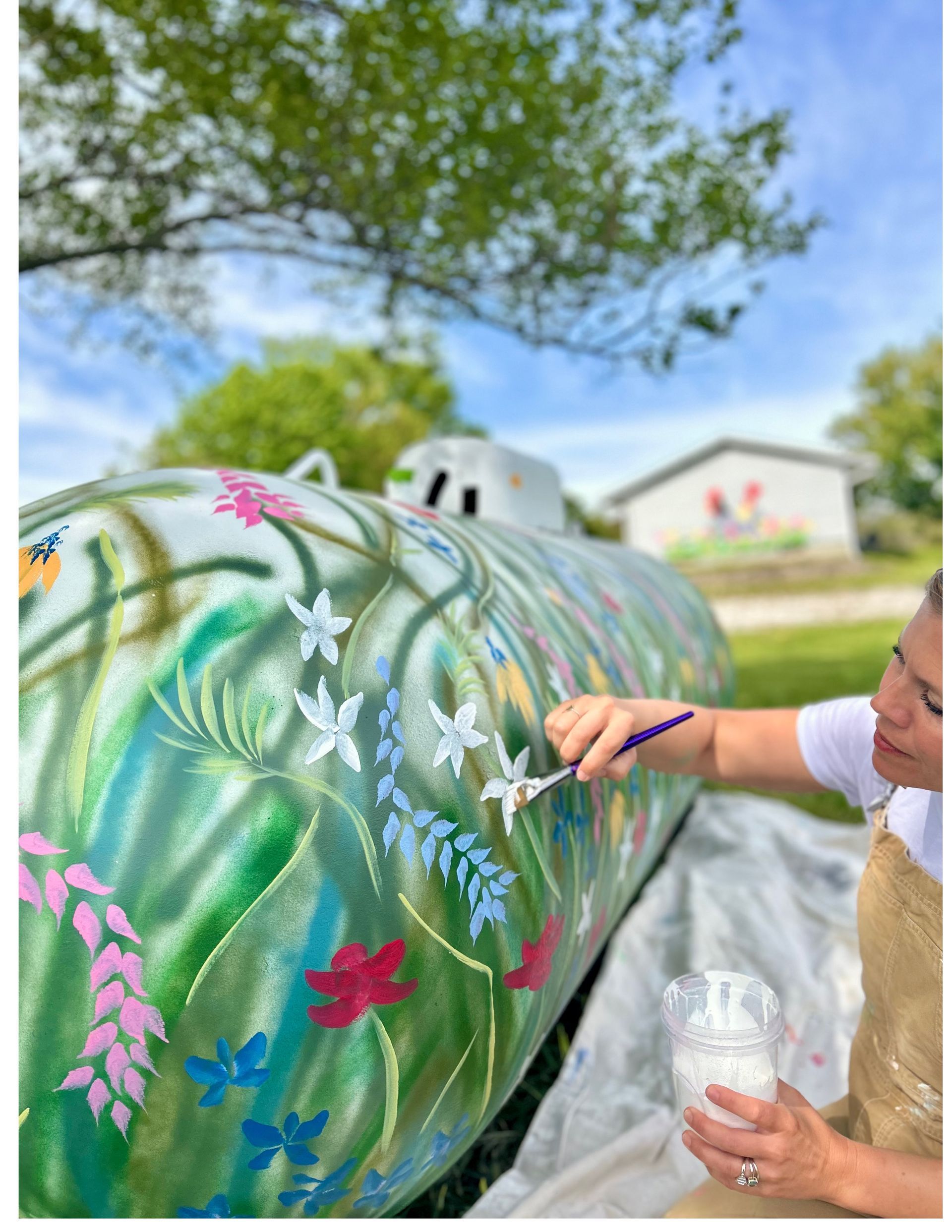 Christine Hilbert painting on a water tank for a mural