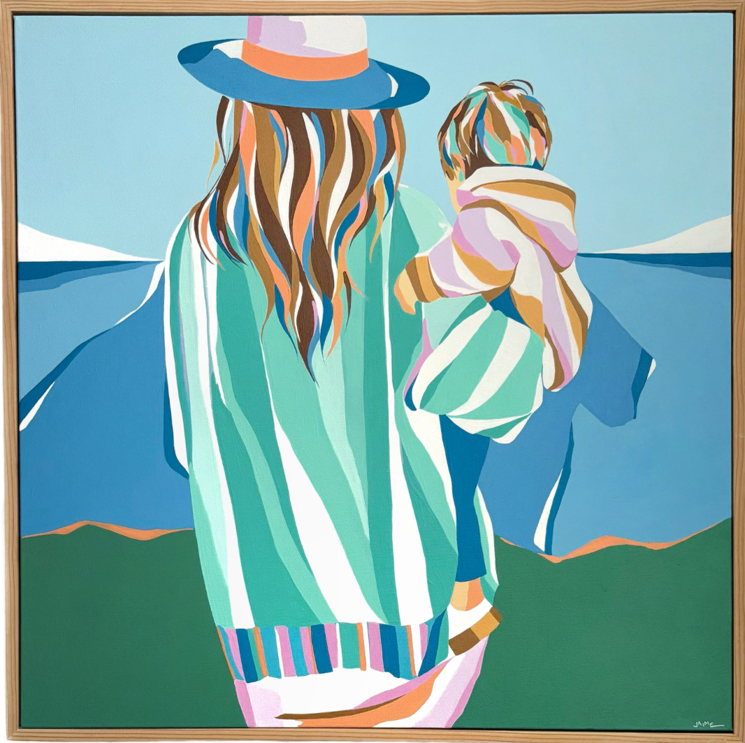 Woman holding a child walking towards the water