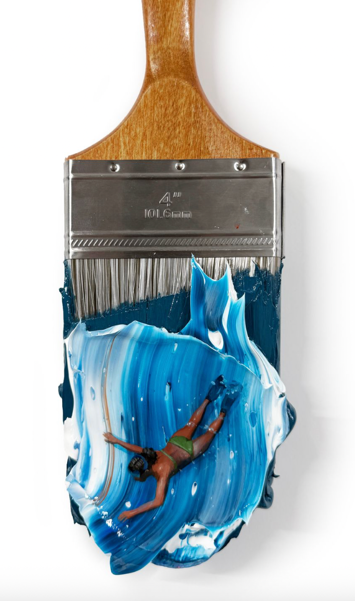 blue and white wave background with woman wearing green swimsuit and flippers acting as through she is swimming through the wave