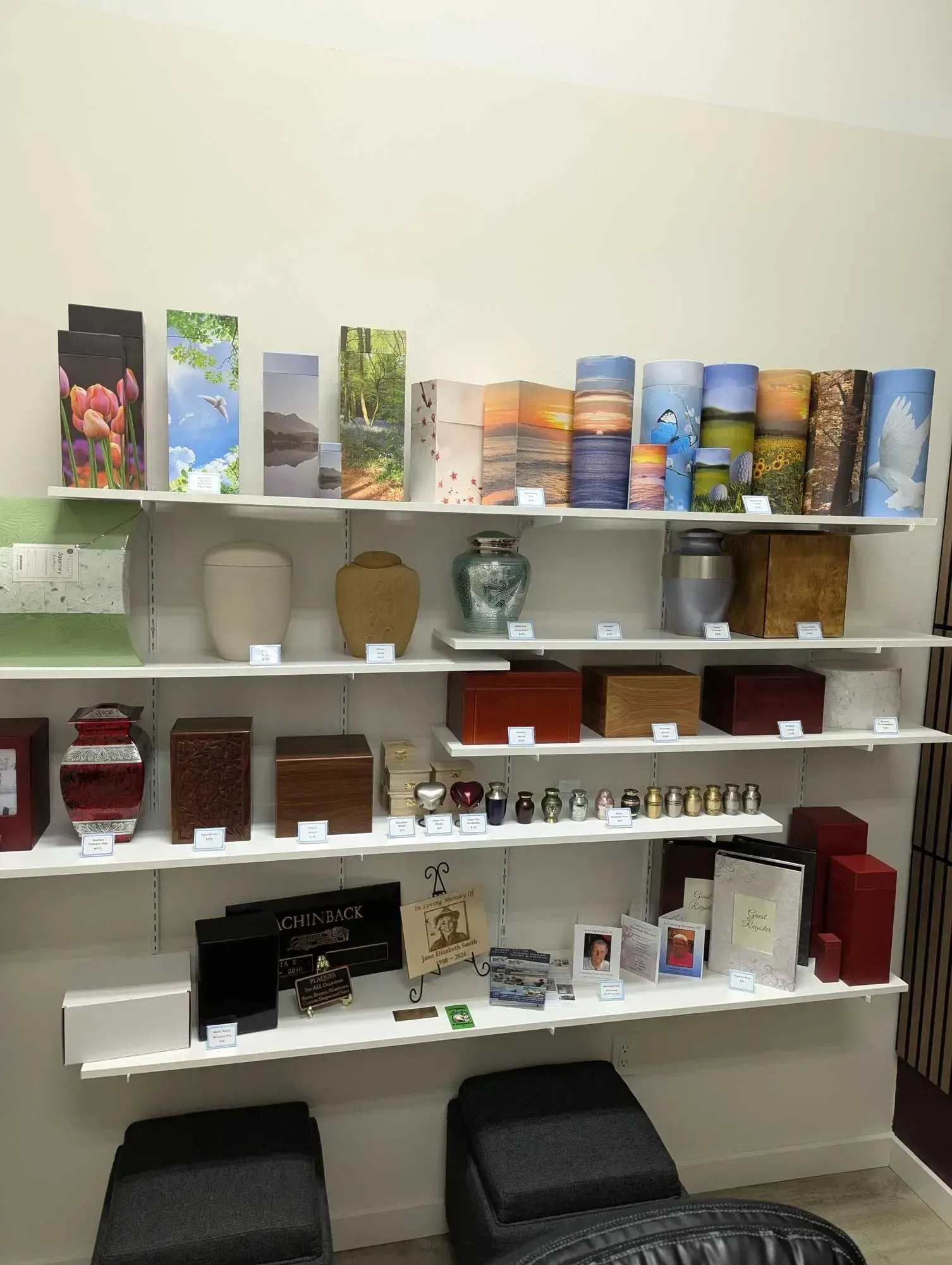 Shelves displaying various cremation urns and memorial items in a retail setting.
