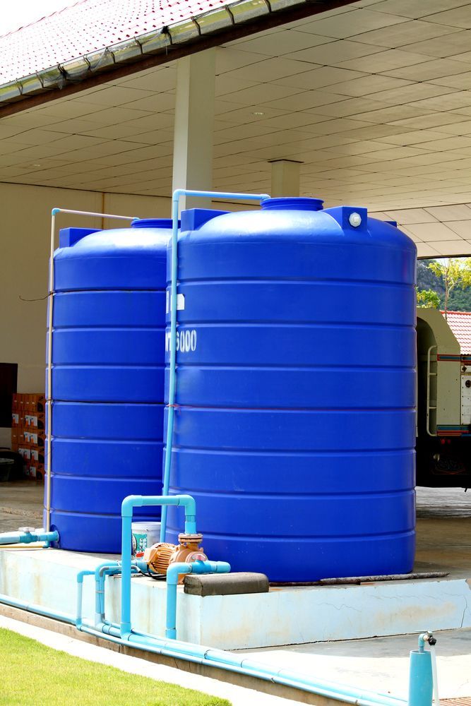 Two Blue Water Tanks Are Sitting Next to Each Other — Sue's Clear Water in Marian, QLD 
