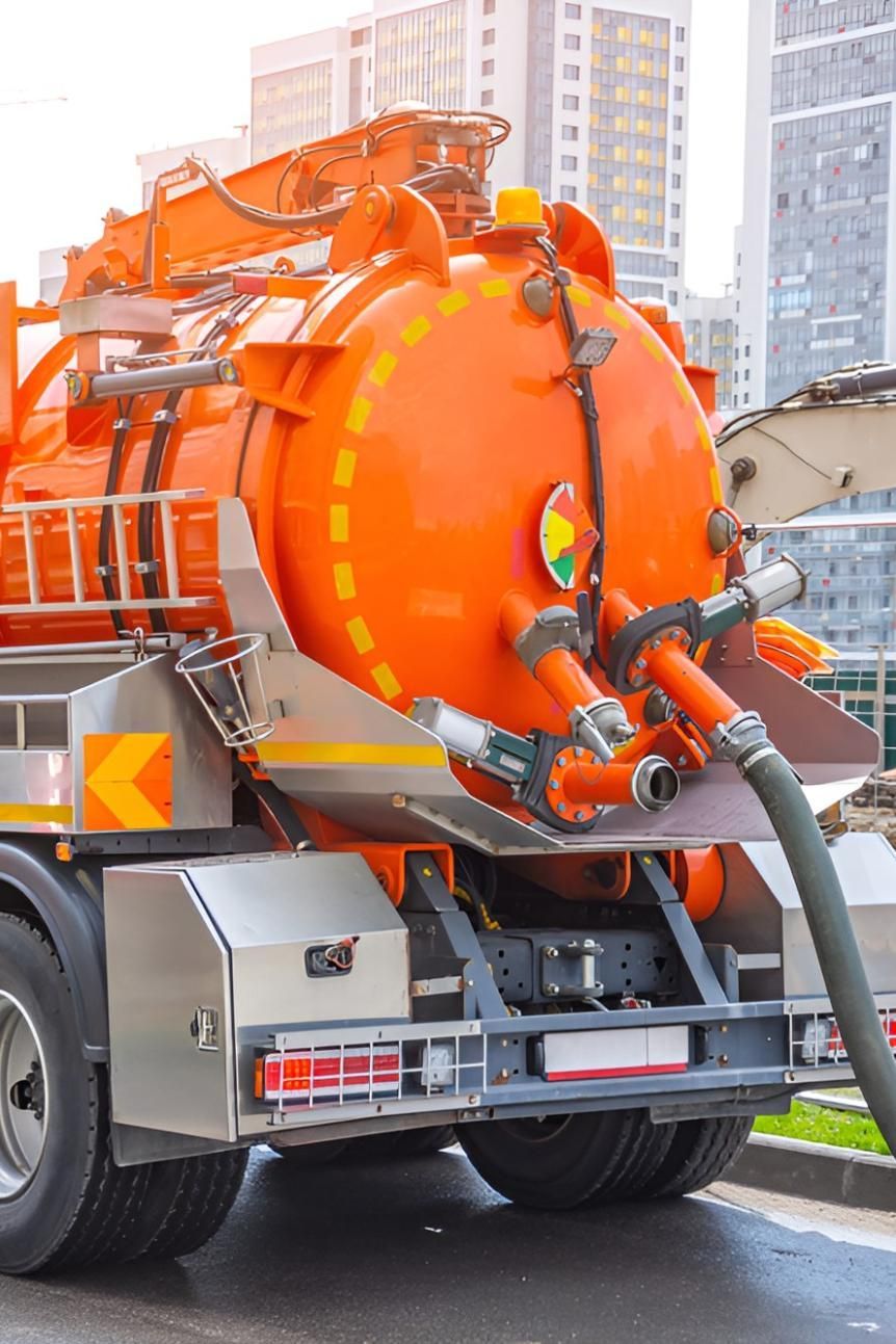 An Orange Vacuum Truck is Driving Down a City Street — Sue's Clear Water in Walkerston, QLD 