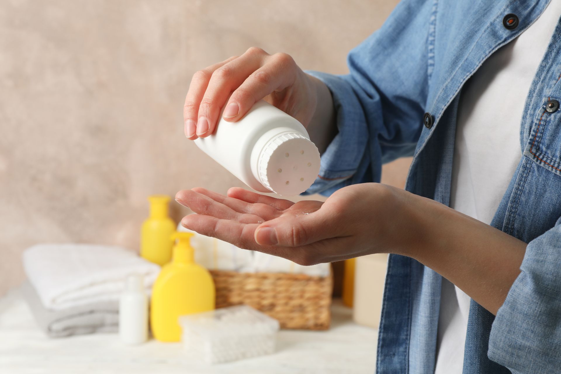 A woman is pouring baby powder into her hand.