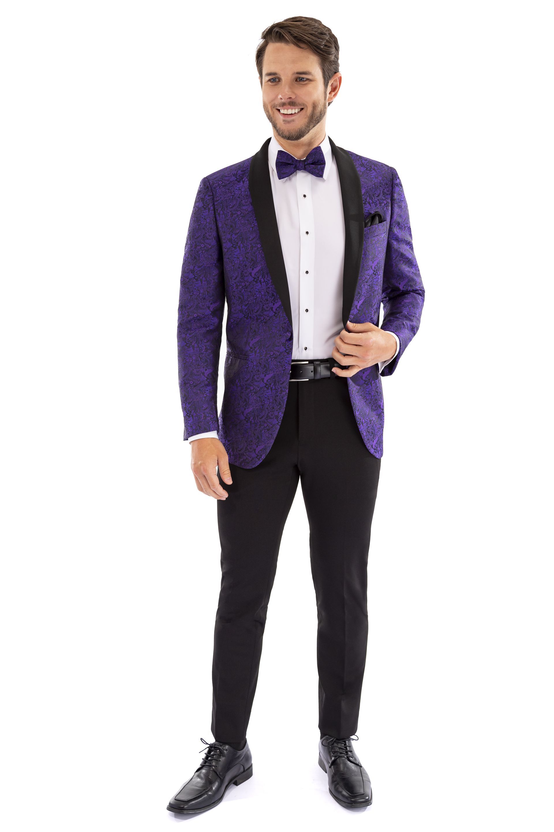 A man is wearing a purple tuxedo jacket and black pants.