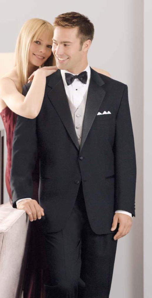 A man in a tuxedo is standing next to a woman in a red dress