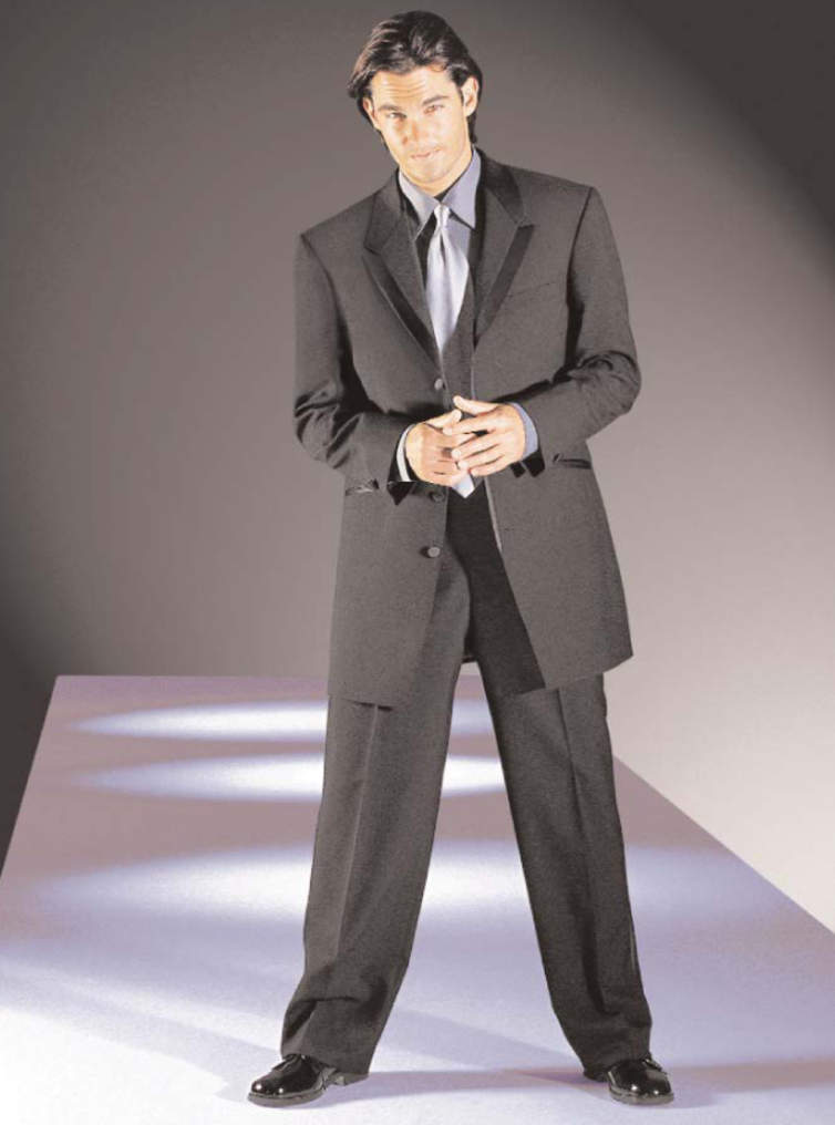 A man in a suit and tie is standing with his hands folded