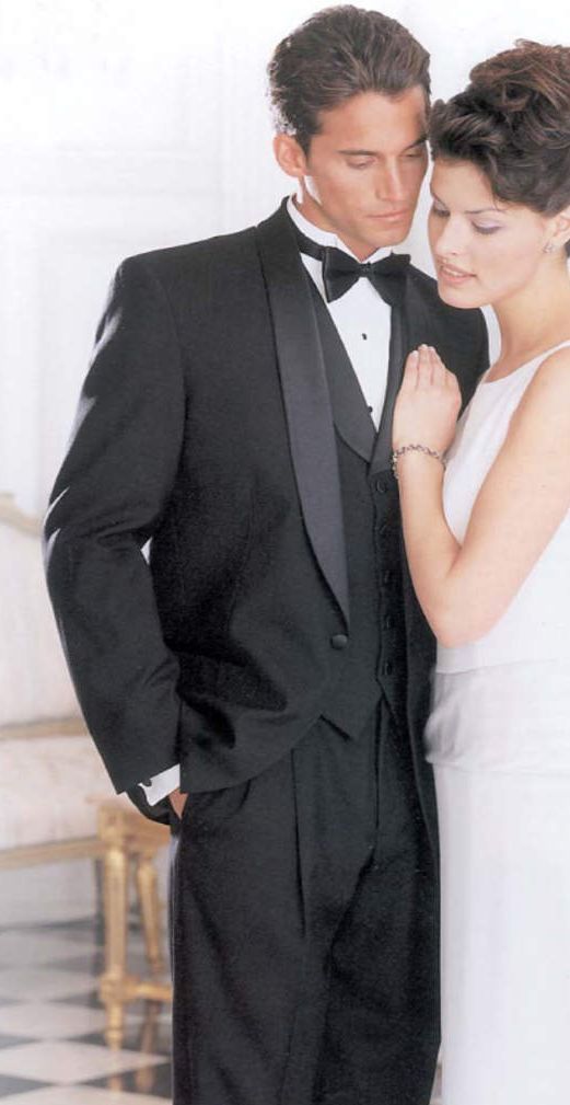 A man in a tuxedo is standing next to a woman in a white dress