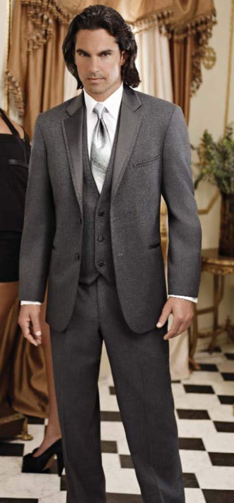 A man in a suit and tie is standing next to a woman in a black dress