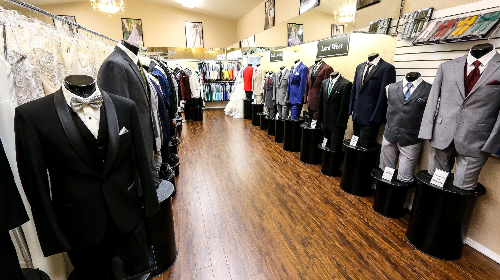 A store filled with lots of suits and dresses on mannequins.