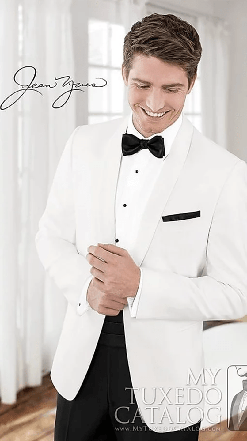 A man is wearing a white tuxedo and a black bow tie.