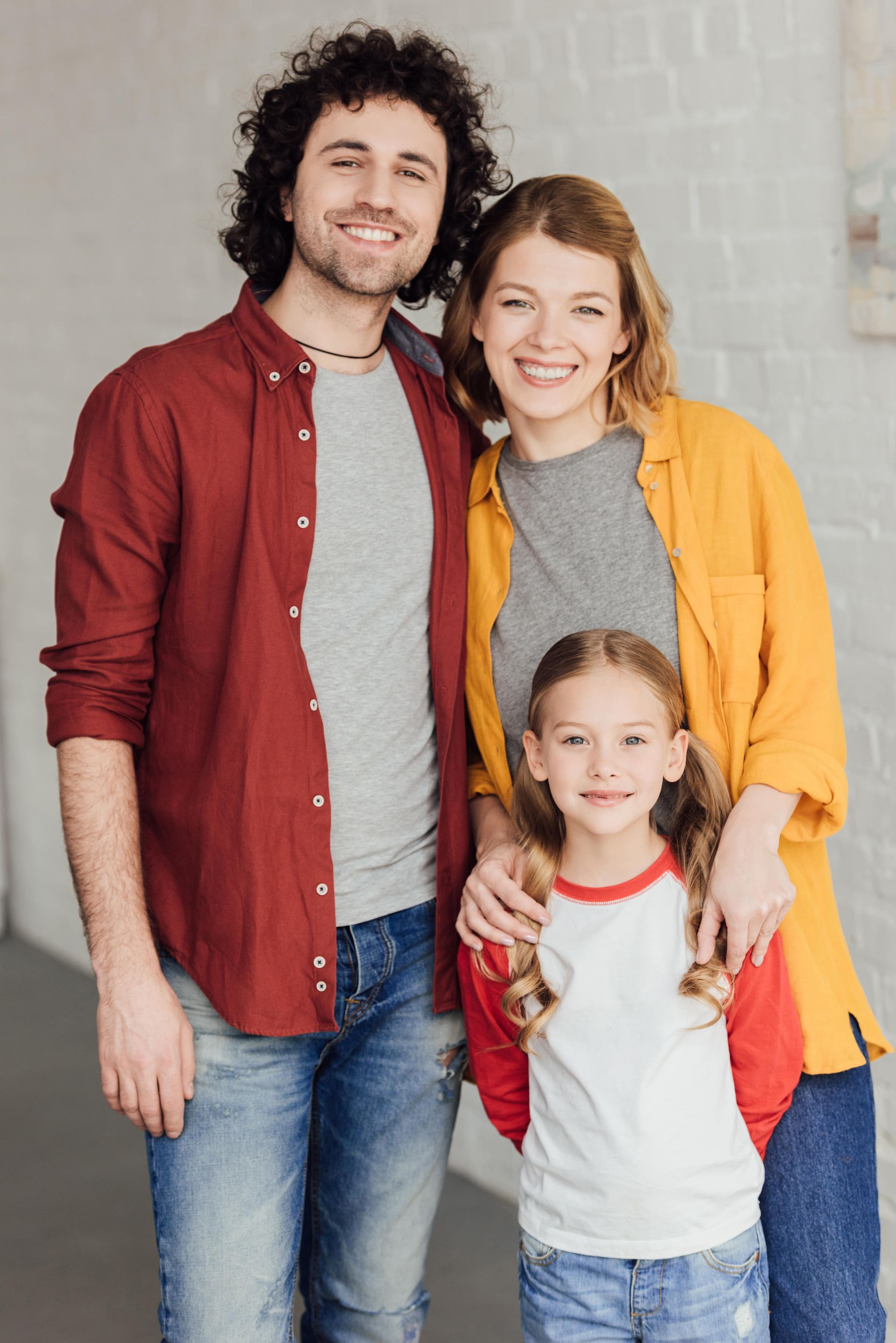 A man , woman and child are posing for a picture together.