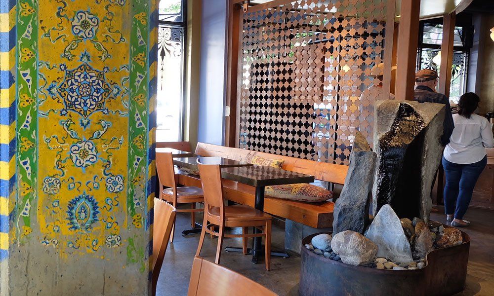 A restaurant with tables and chairs and a water fountain