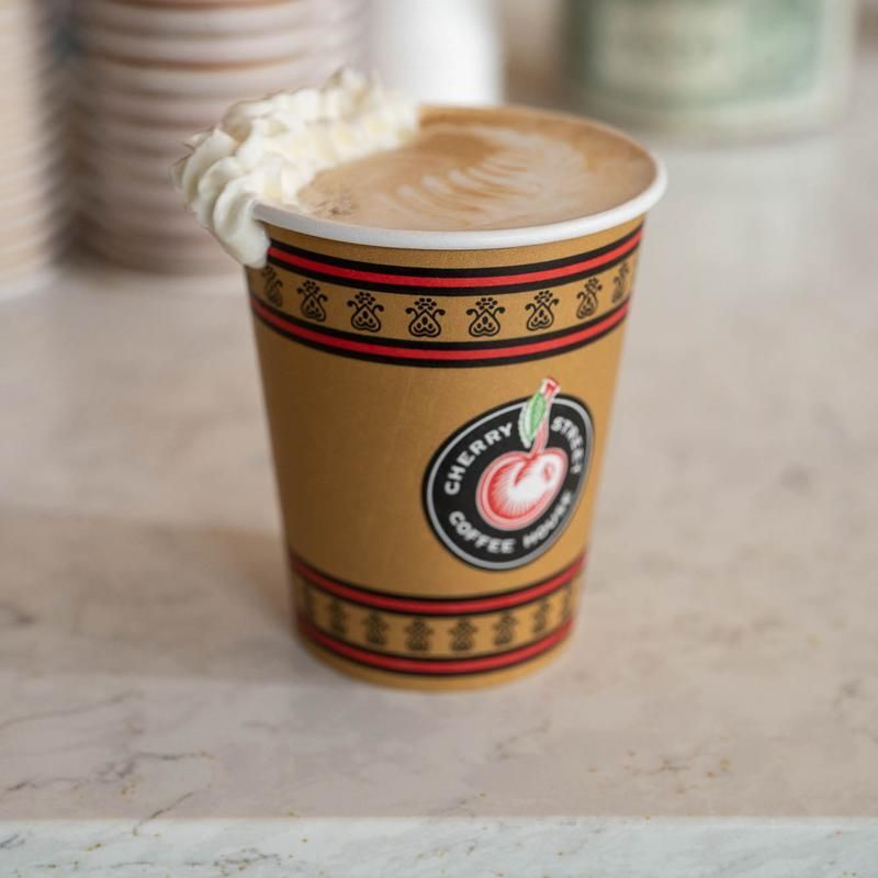 A cup of cherry tree coffee with whipped cream on top