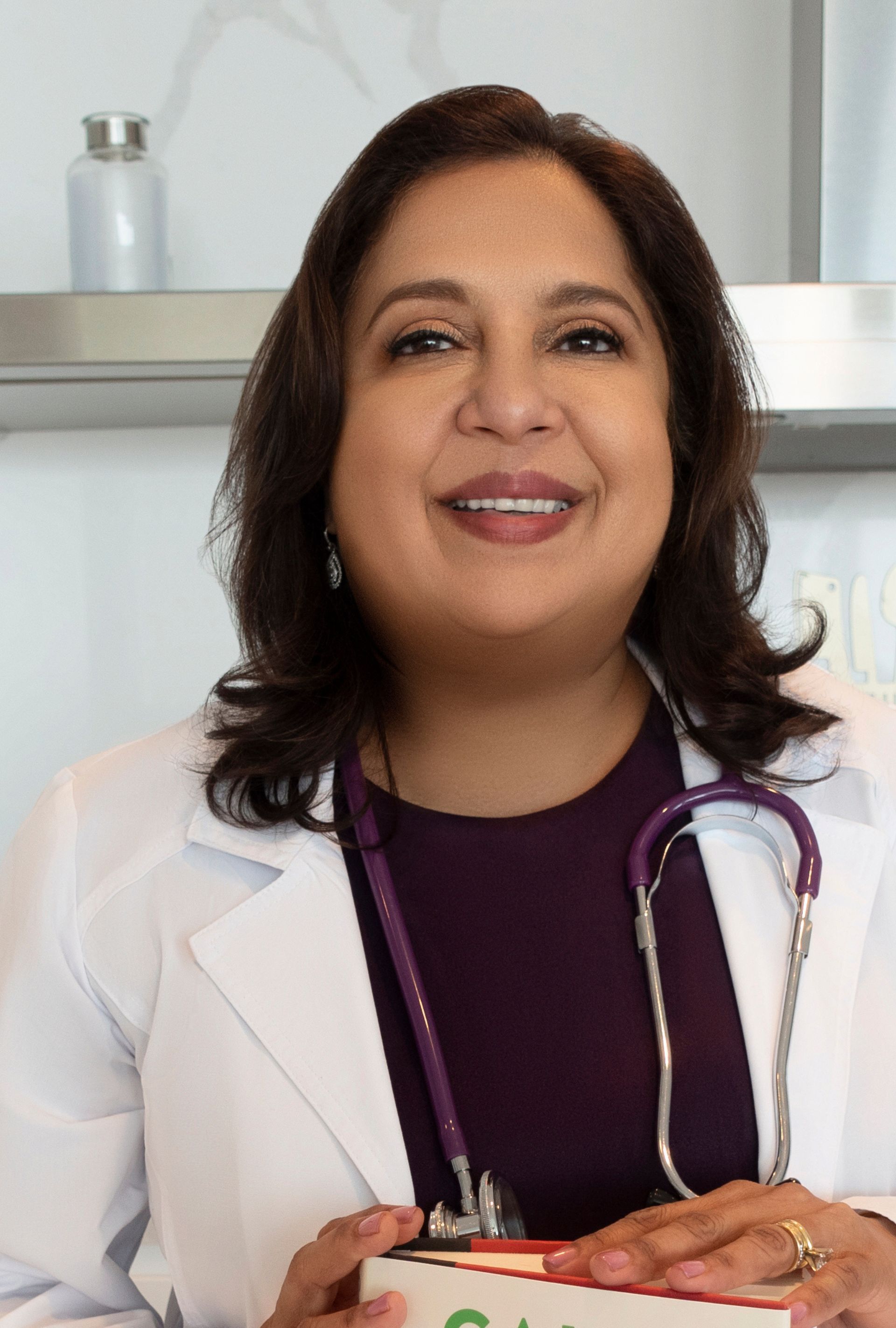 A woman in a lab coat with a stethoscope around her neck