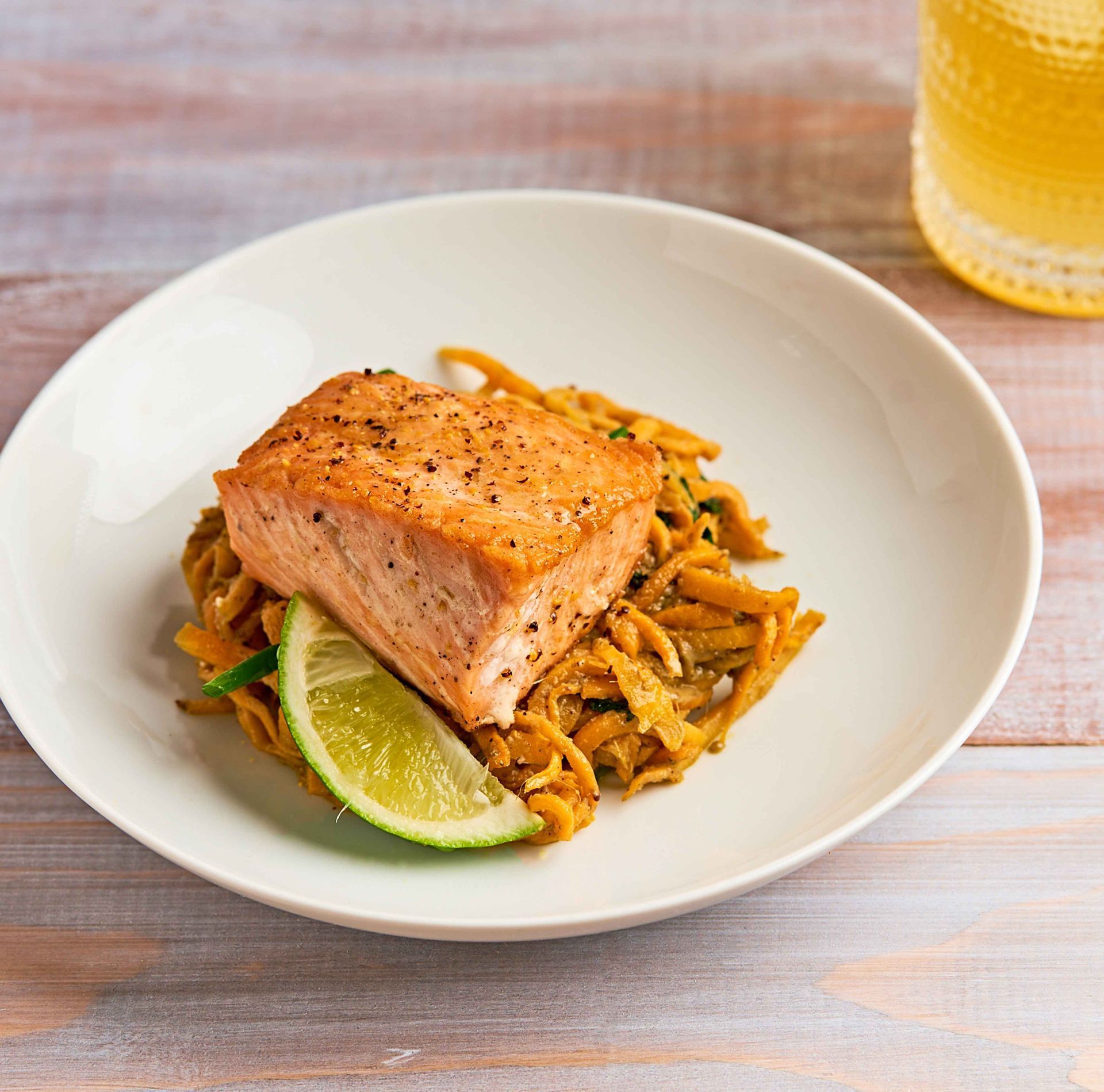 The LUV Diet by Dr. David Perlmutter and Daily Dose—organic, uric acid-lowering meal featuring wild-caught salmon with nutrient-dense vegetable noodles and a fresh lime wedge. Designed to support metabolic health, weight management, and longevity.