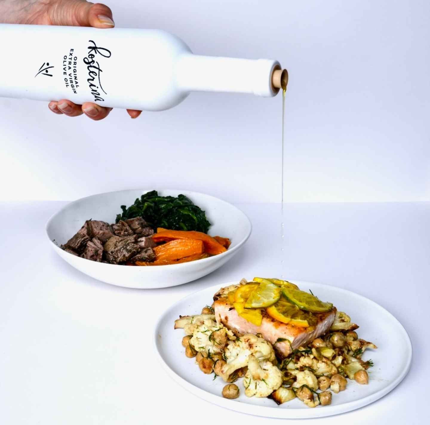A stack of Daily Dose Modern Mediterranean meal plan containers next to a bottle of Kosterina extra virgin olive oil. A hand lifts a forkful of Mediterranean-inspired ingredients, including olives, roasted vegetables, and seasoned protein. A chef-crafted, ready-to-eat meal designed for longevity and wellness.