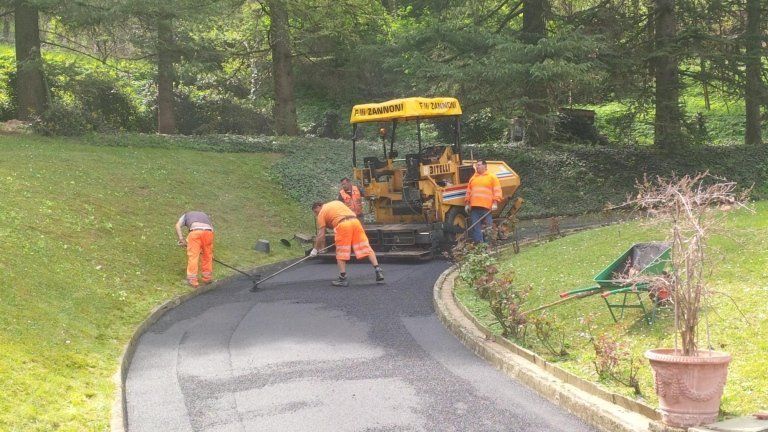 operai con macchina per stesura asfalto