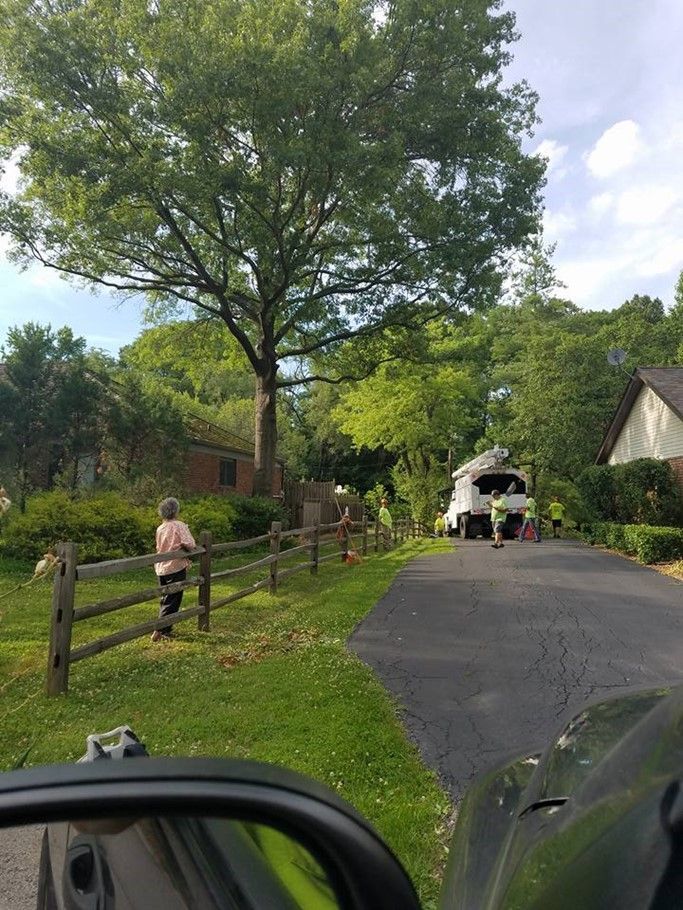 A woman is walking down a street next to a wooden fence.