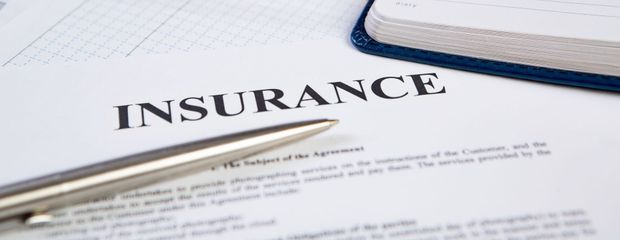 Insurance document with glasses and pen on a desk Insurance document with glasses and pen on a desk