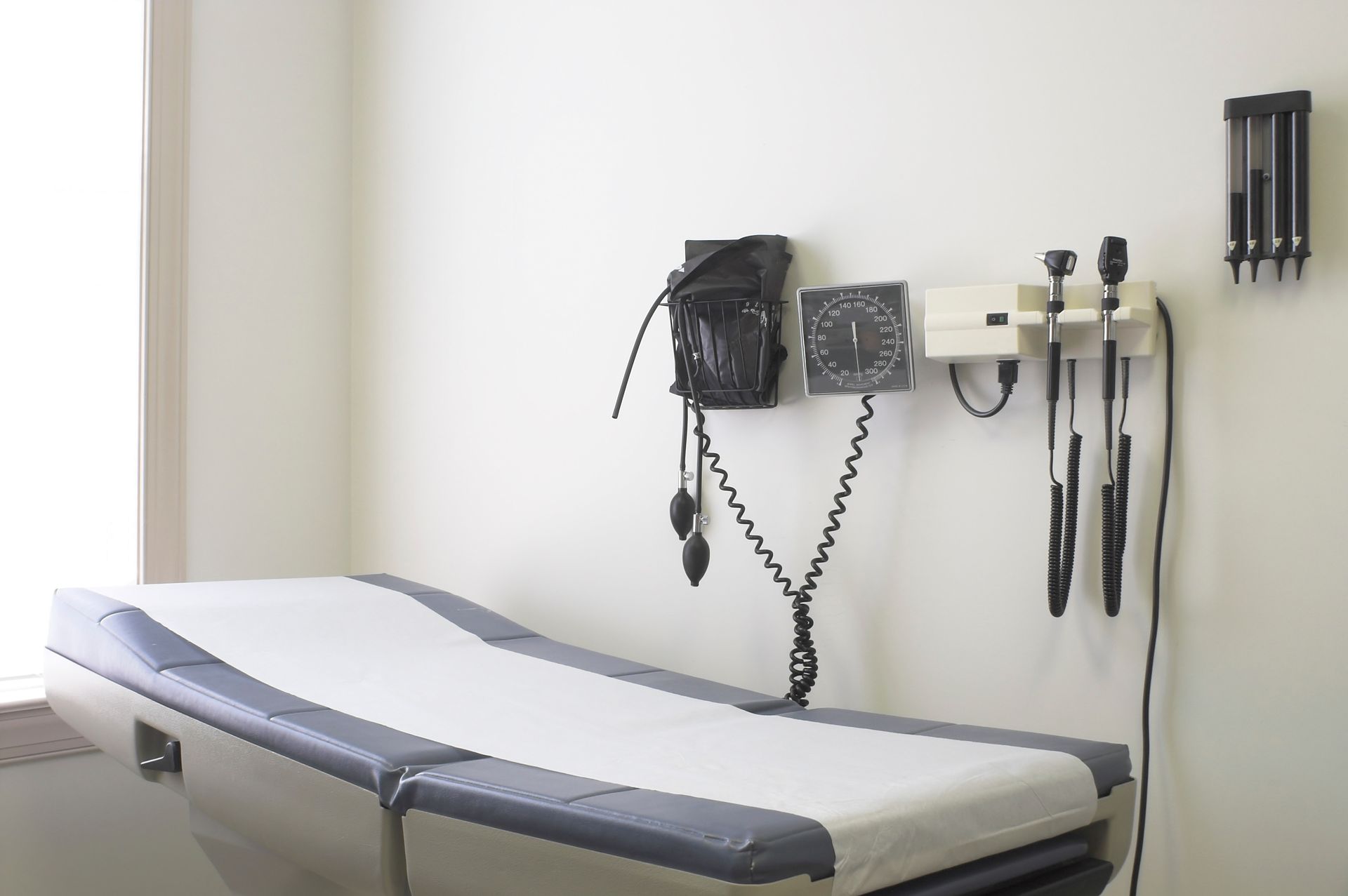 Examination room with medical exam table and wall-mounted diagnostic tools