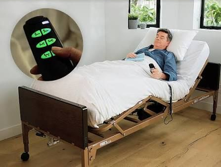 Caregiver assists a person in a mobility lift in a bright bedroom near a window Adjustable hospital bed with lightweight sturdy components and wooden side rails in a showroom