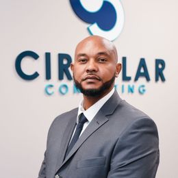 a man in a suit and tie is standing in front of a sign that says circular consulting