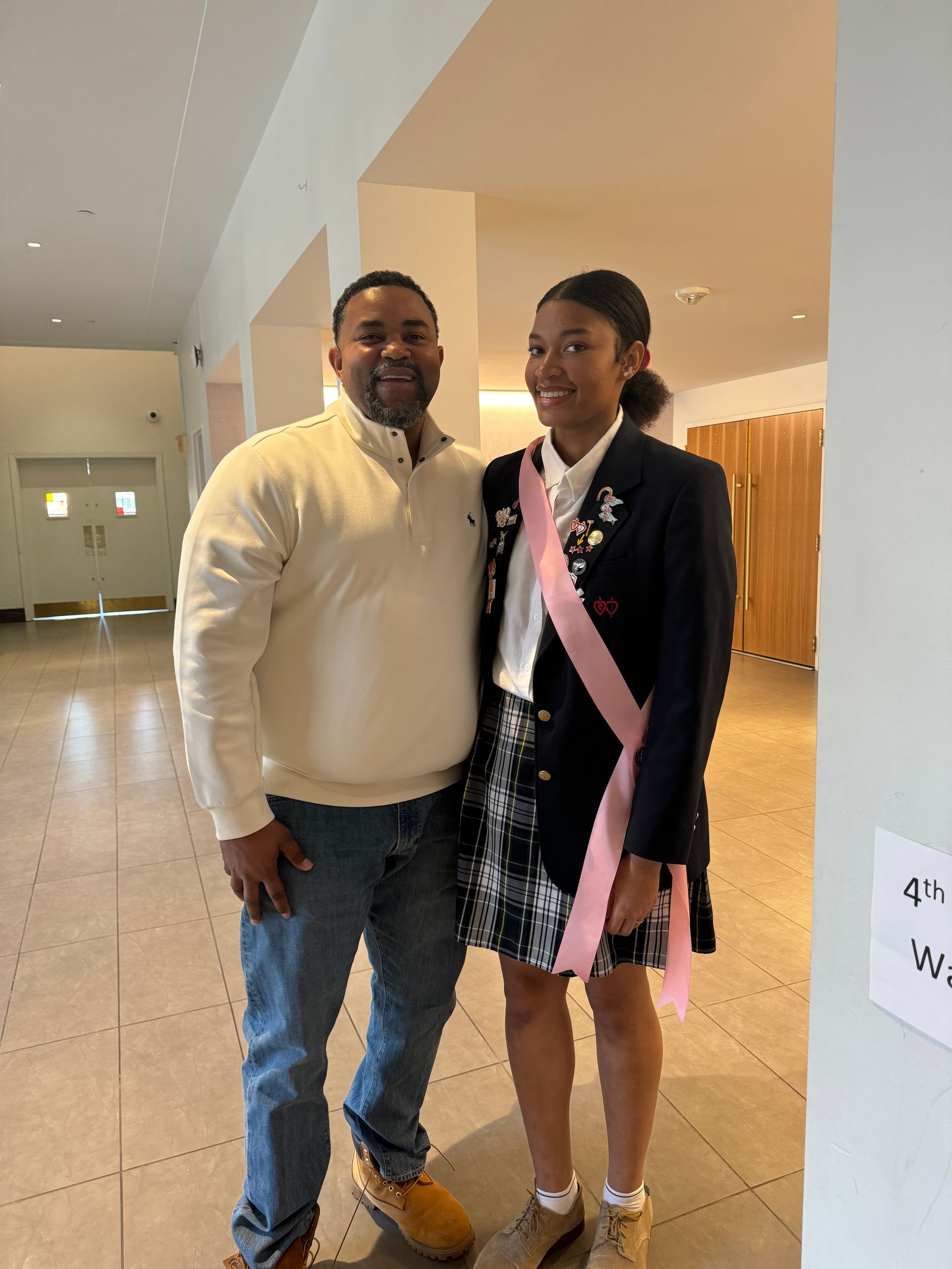 A man and a girl are posing for a picture in a hallway