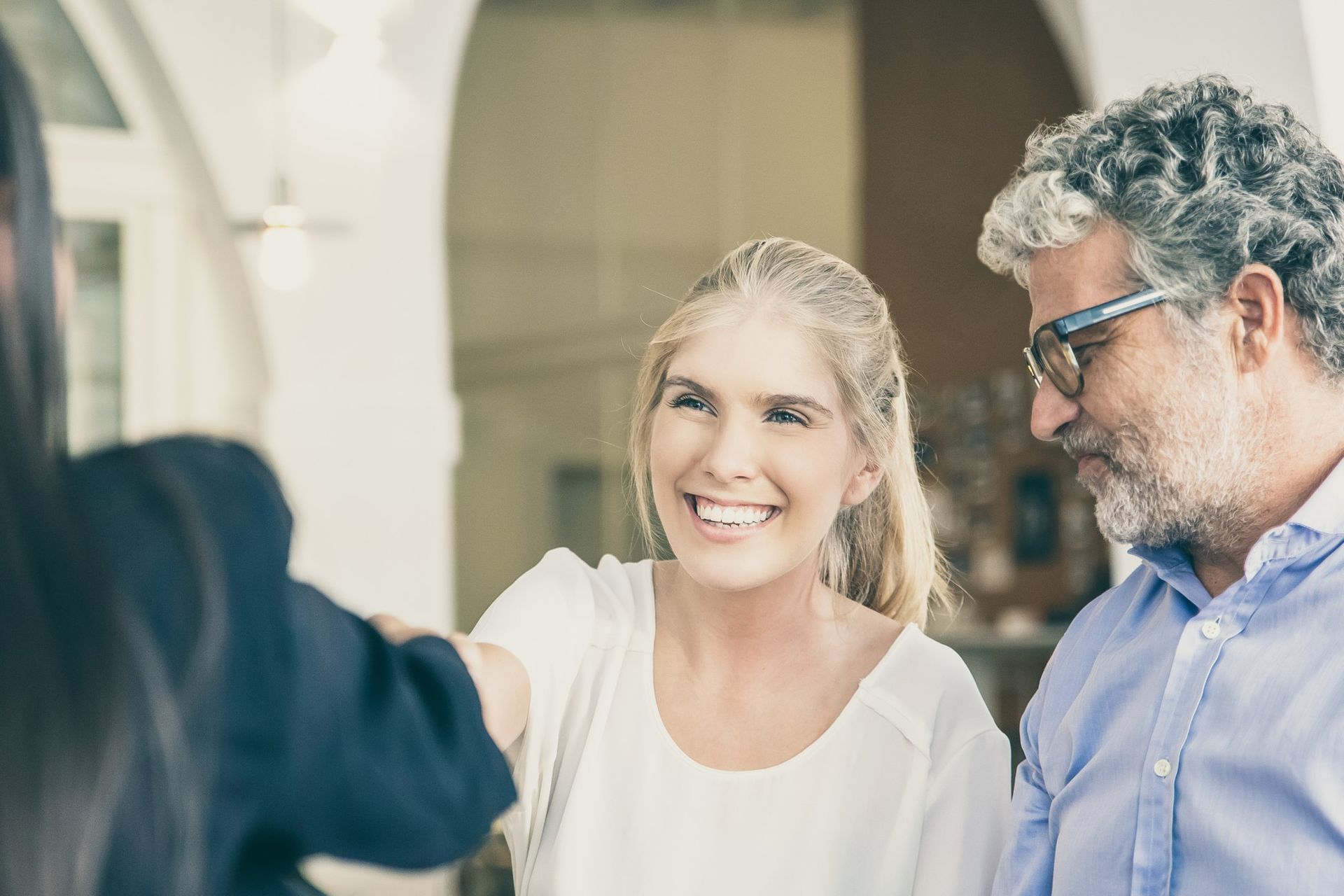 A man and a woman are shaking hands with a woman.