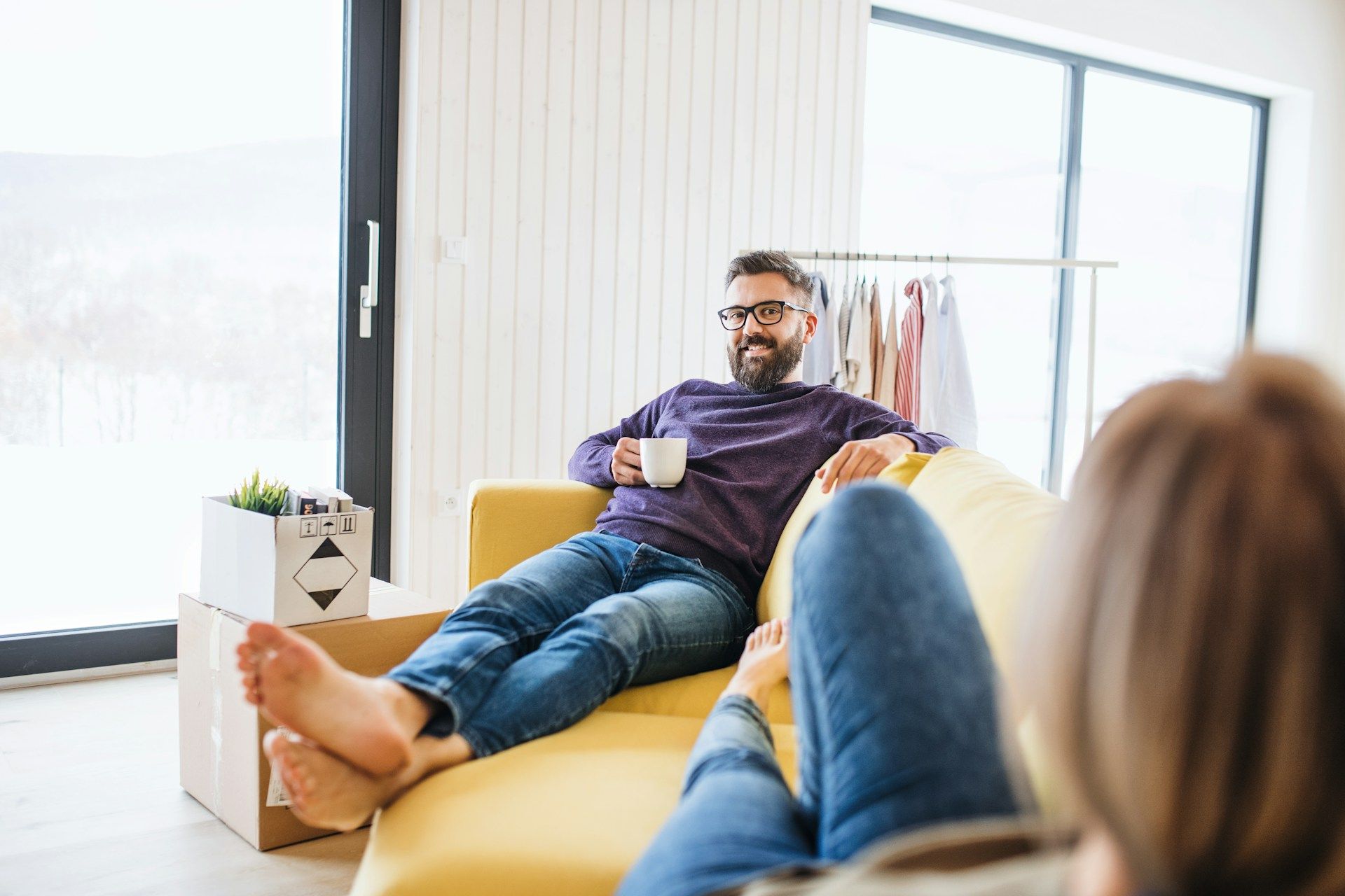 A man and a woman are sitting on a couch in a living room.