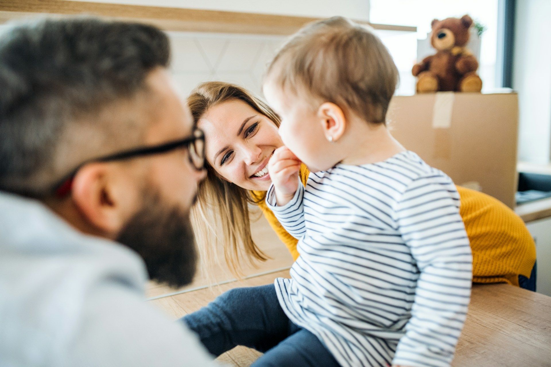 A man and woman are sitting on the floor with a baby.