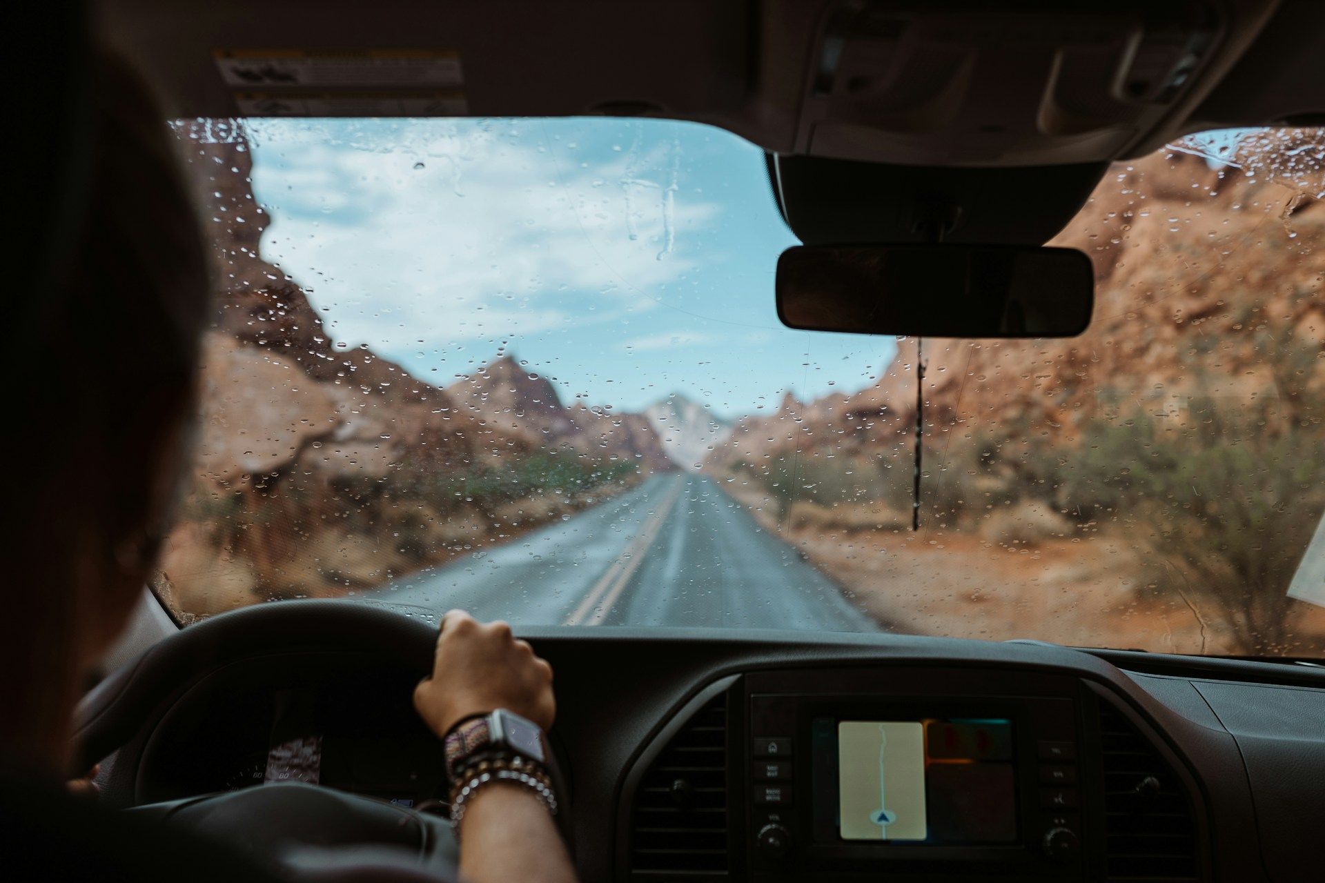 A person is driving a car down a desert road.