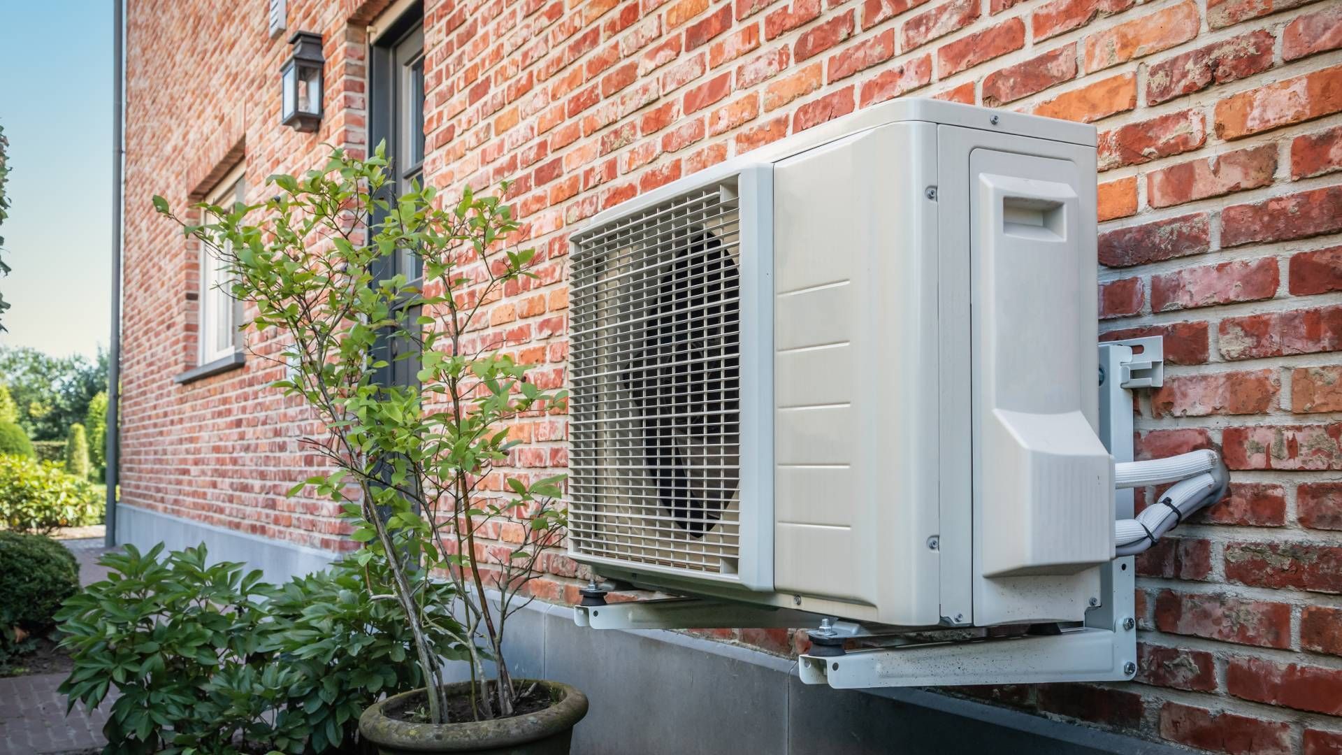 A new heat pump installation near Lexington, KY, outside of a beautiful red brick home at Advantage Air HVAC near Lexington, KY