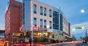 Building exterior: multi-story with RWJ logo, street sign 