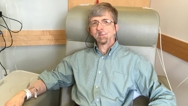 A man sitting in a chair receiving dialysis treatment
