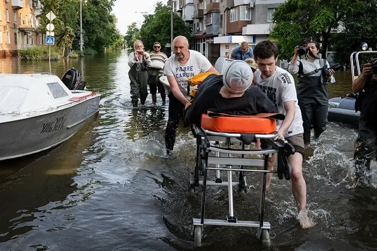 People being evacuated following flooding caused by the destruction of the Kakhovka dam in Ukraine.