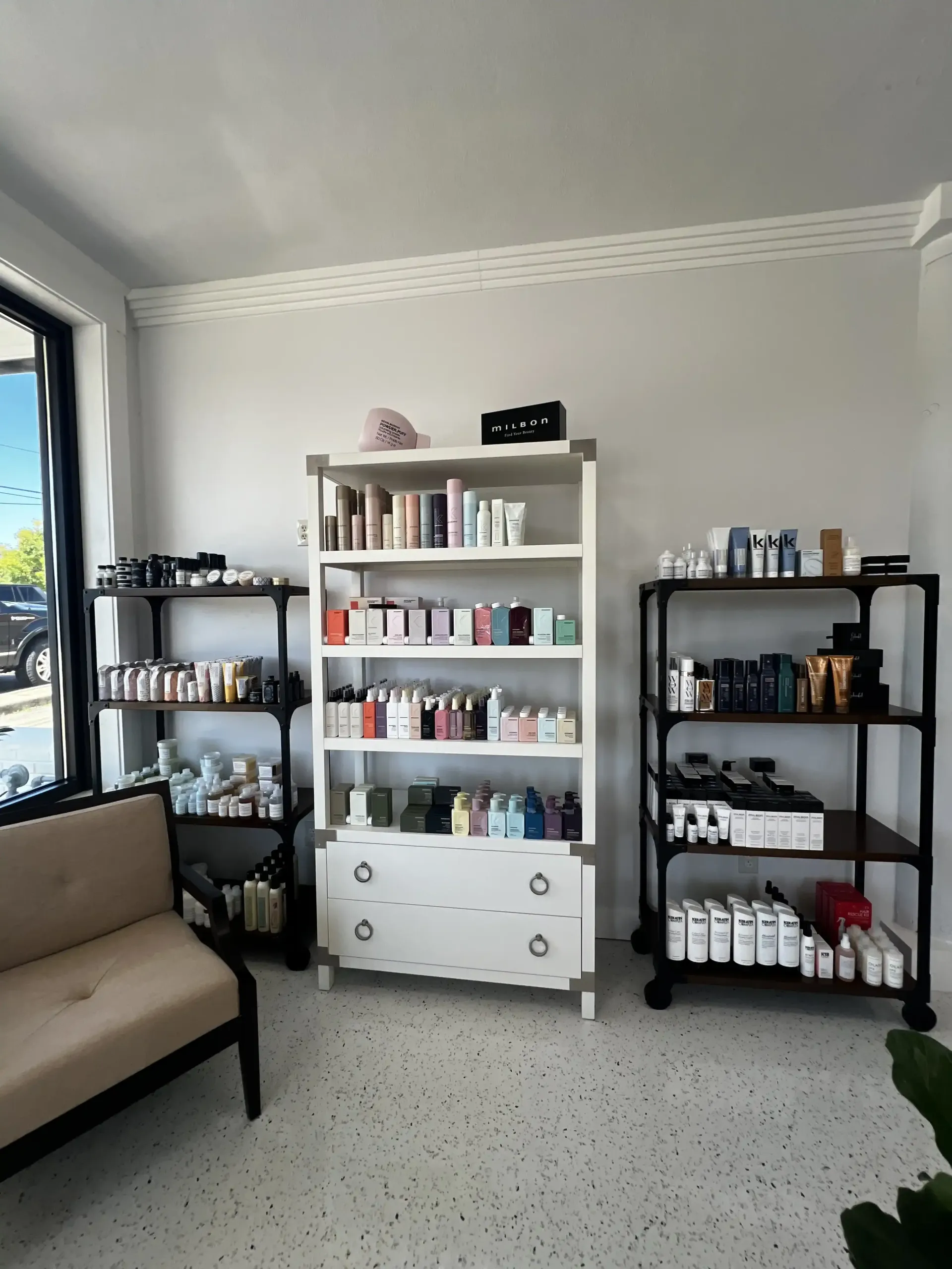 A room with a couch and shelves full of beauty products