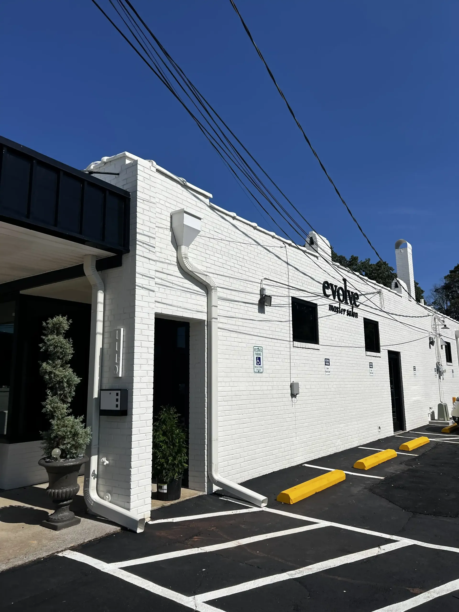 A large white brick building with a parking lot in front of it