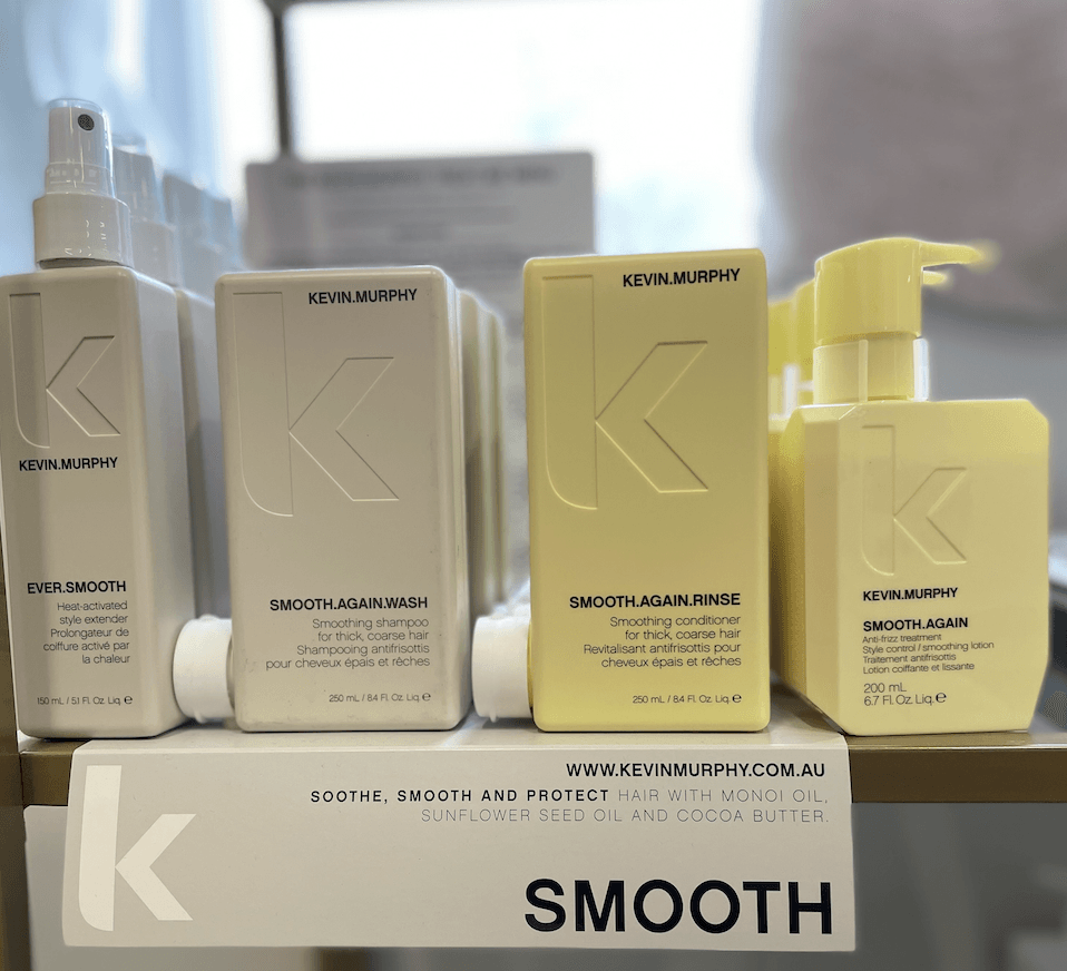 Bottles of kevin murphy products are lined up on a shelf