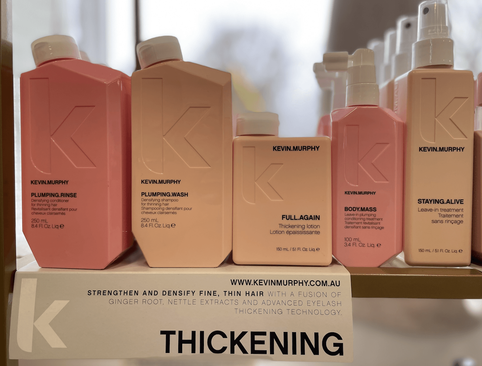 A display of hair products with a sign that says thickening