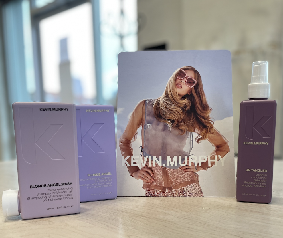 A woman is standing next to a box of kevin murphy hair products