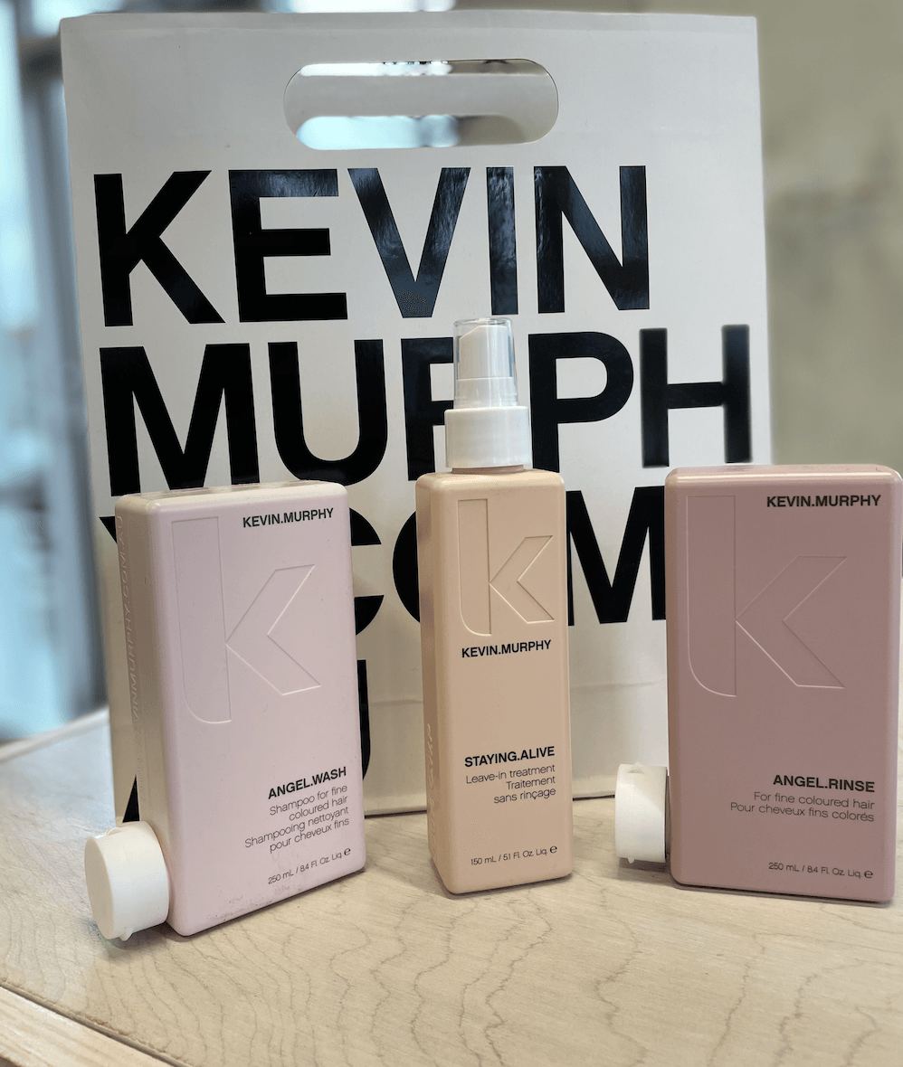 Three bottles of kevin murphy hair products are on a table